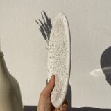 4 black speckled dessert plates on a vintage white background