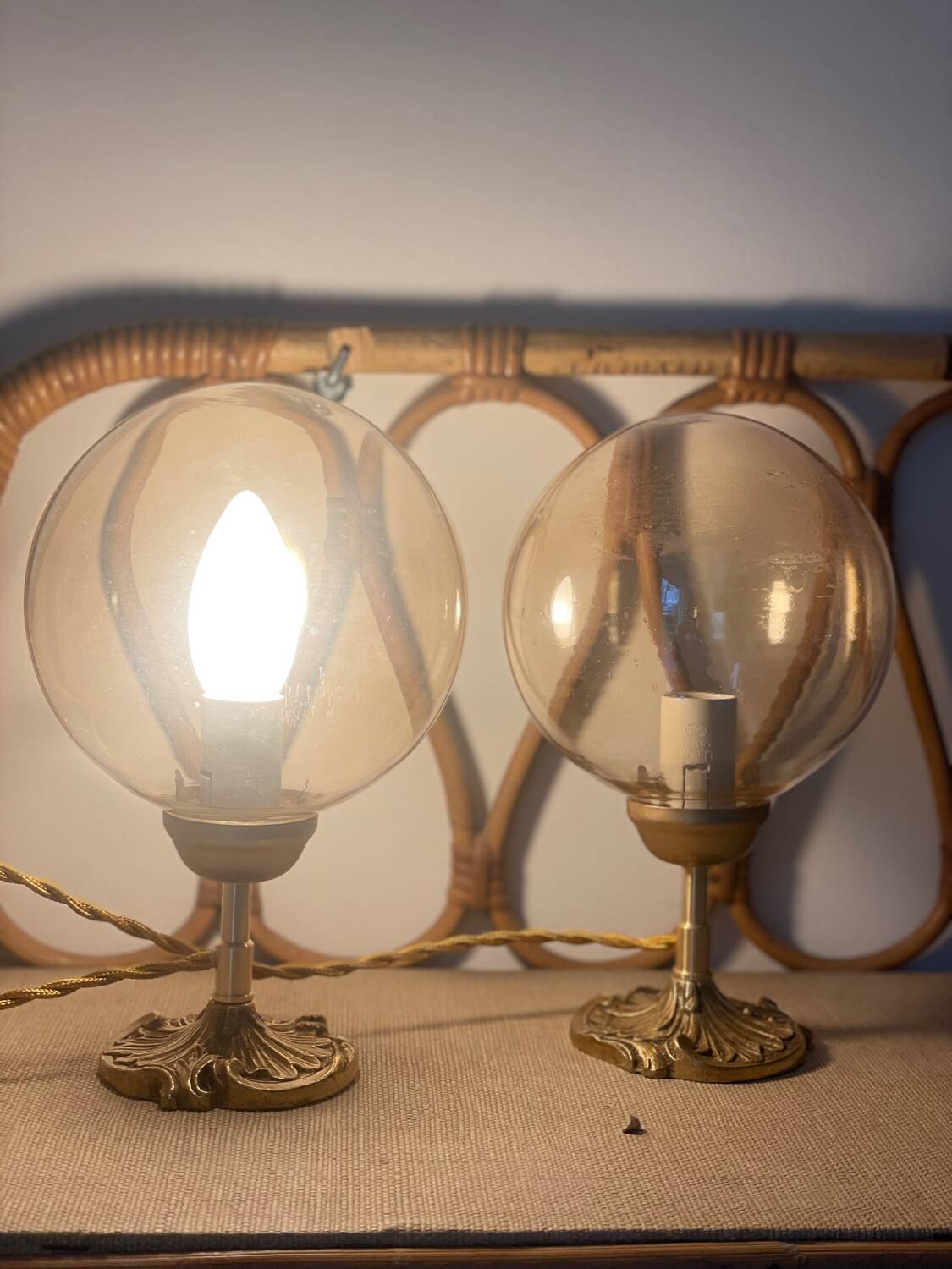 2 bedside lamps with round amber glass globes and gold metal.
