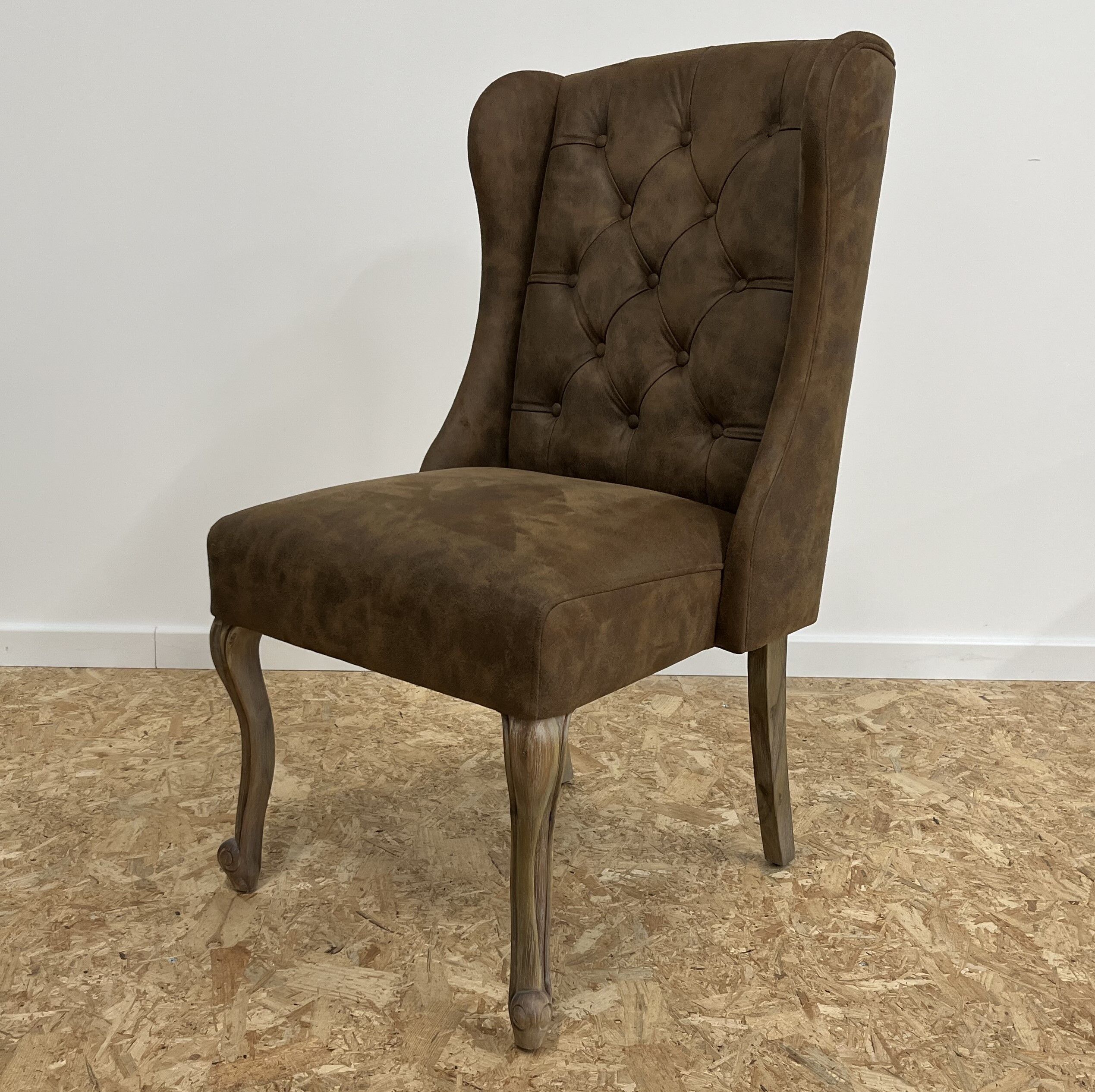 Upholstered armchair in brown imitation leather