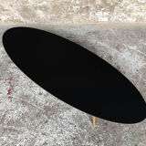 Oval coffee table with a black tray and oak-turned feet