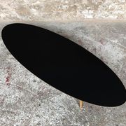 Oval coffee table with a black tray and oak-turned feet