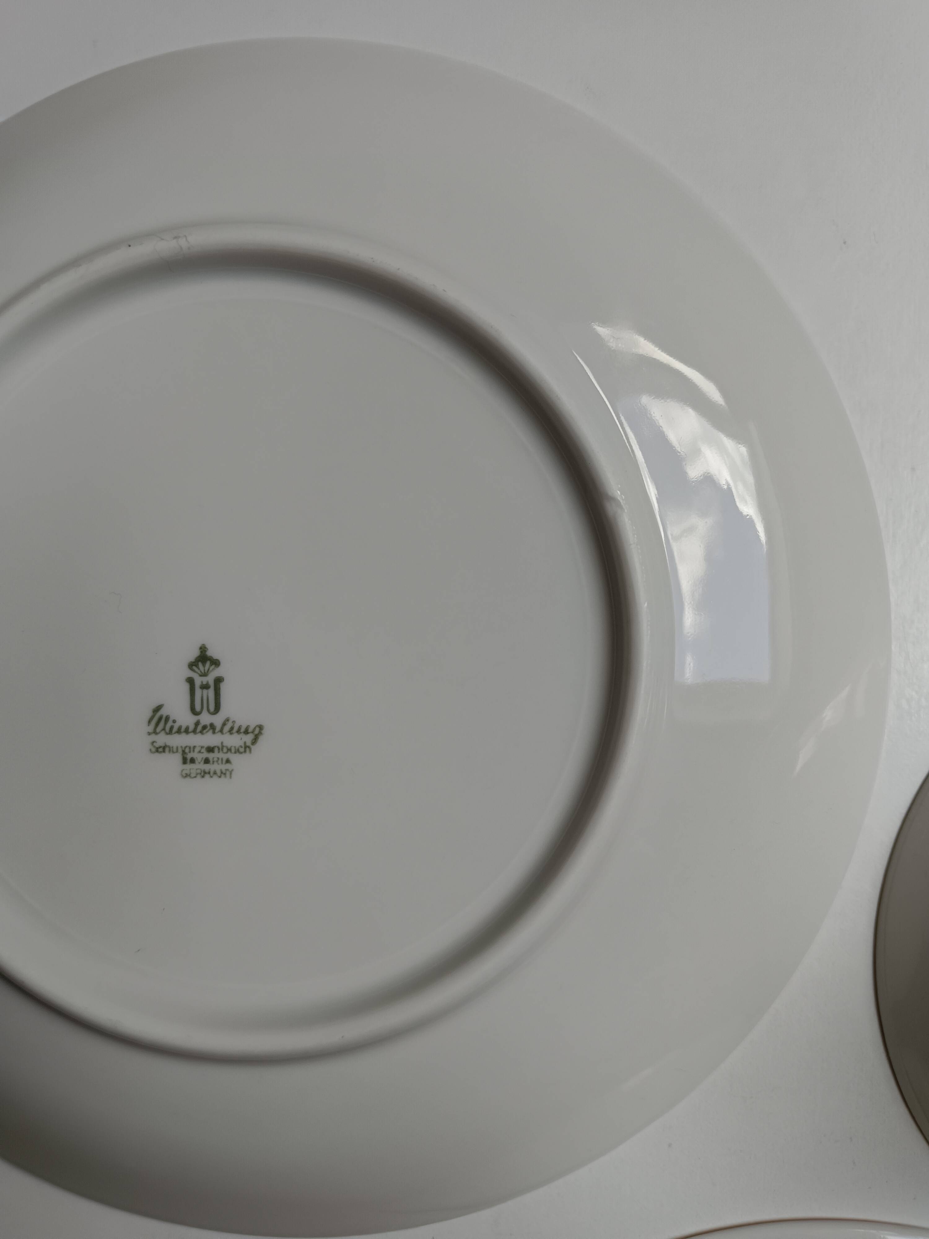 Solitaire tea cup, saucer, and dessert plate in white and gold.