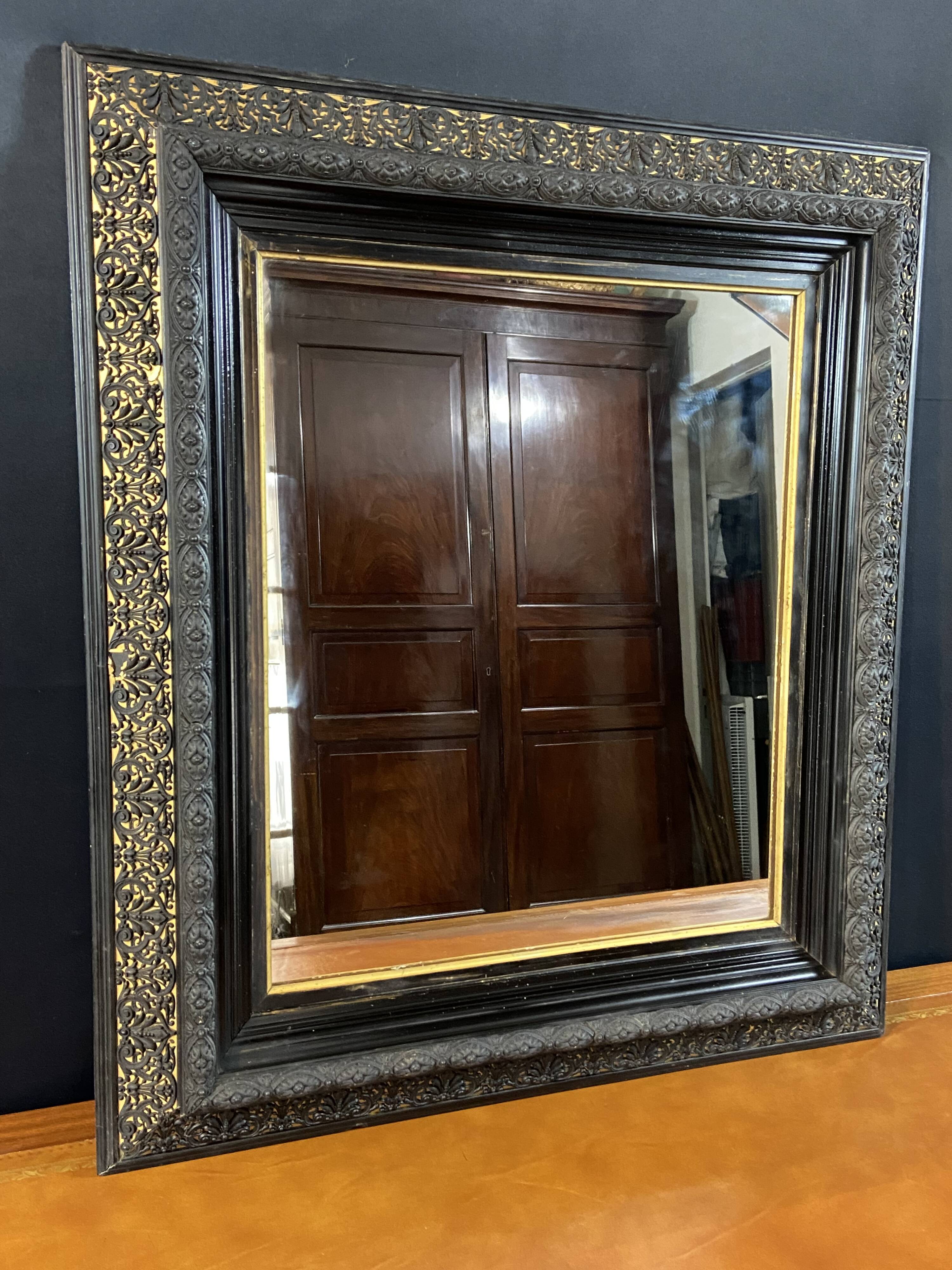 19th-century mirror Napoleon III in blackened wood on a gold background.