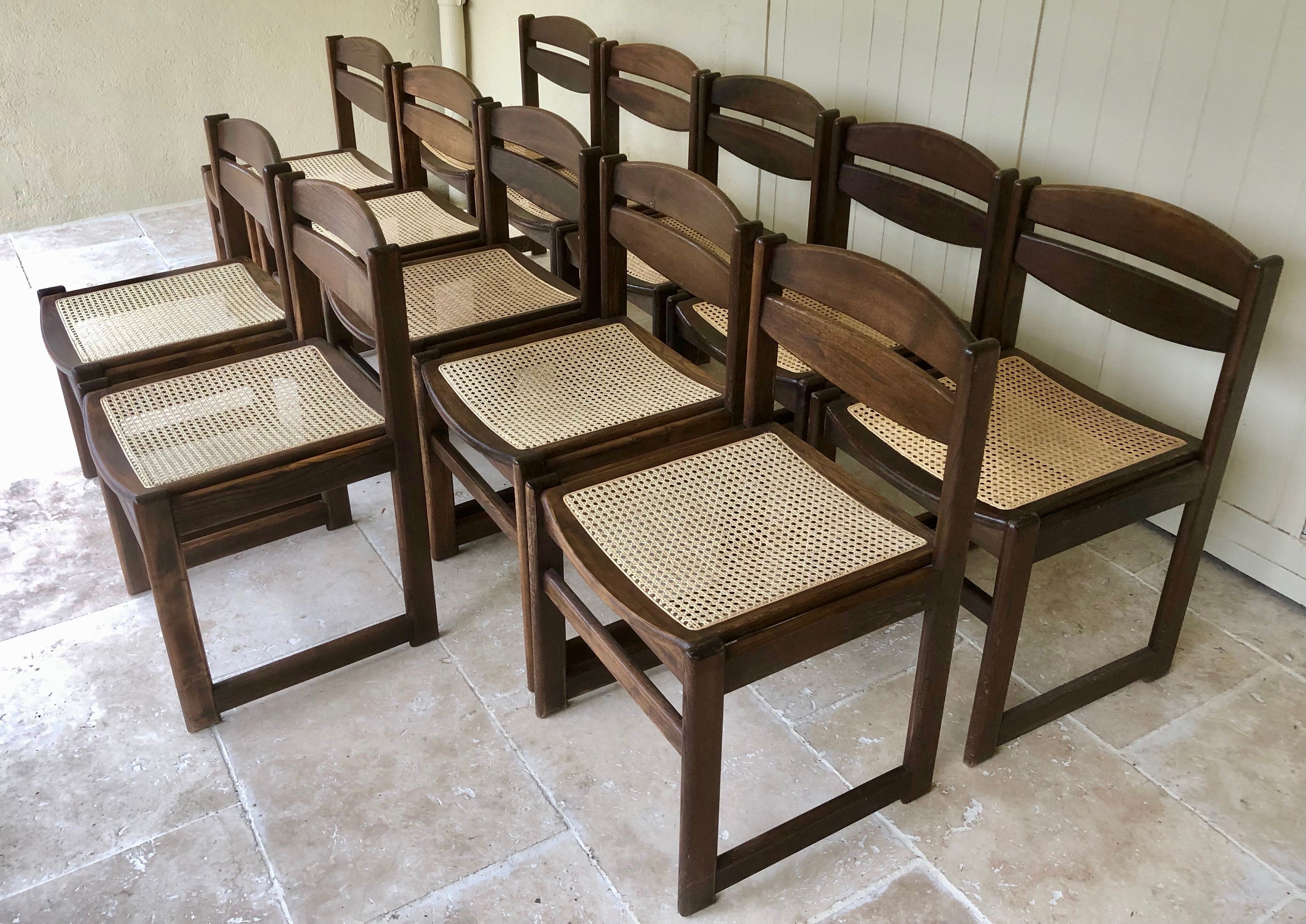 Set of 12 "sledge" dining chairs in walnut and cane.