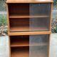 Scandinavian wooden buffet cabinet with sliding glass doors.
