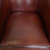 Sheepskin club armchair in a warm deep colour finished with black piping