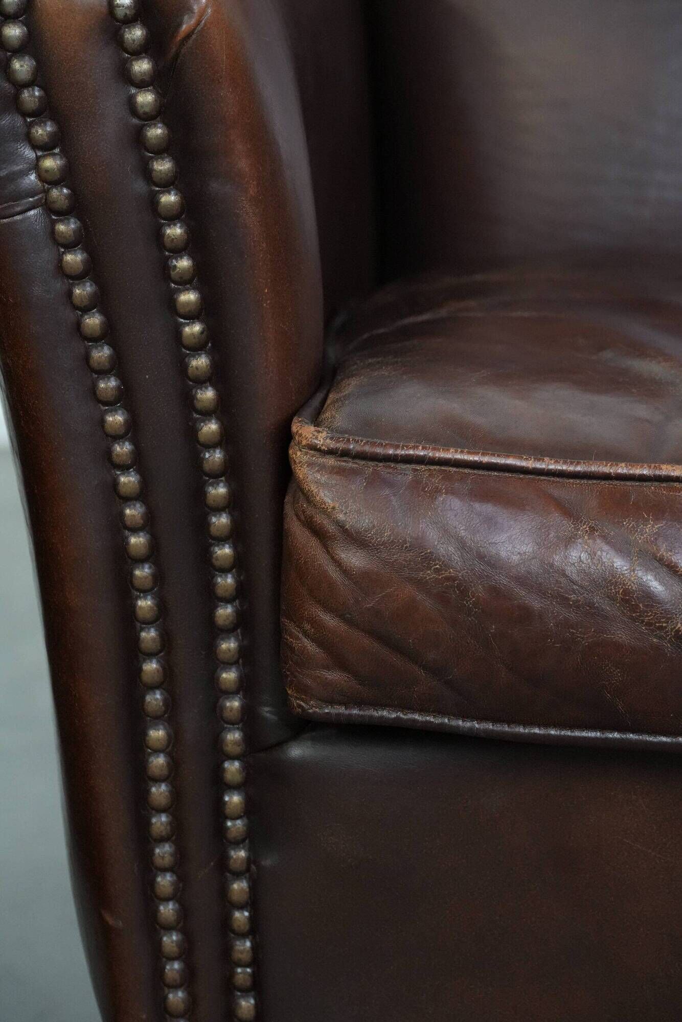 Ensemble de deux fauteuils en cuir de mouton vintage au caractère marqué.
