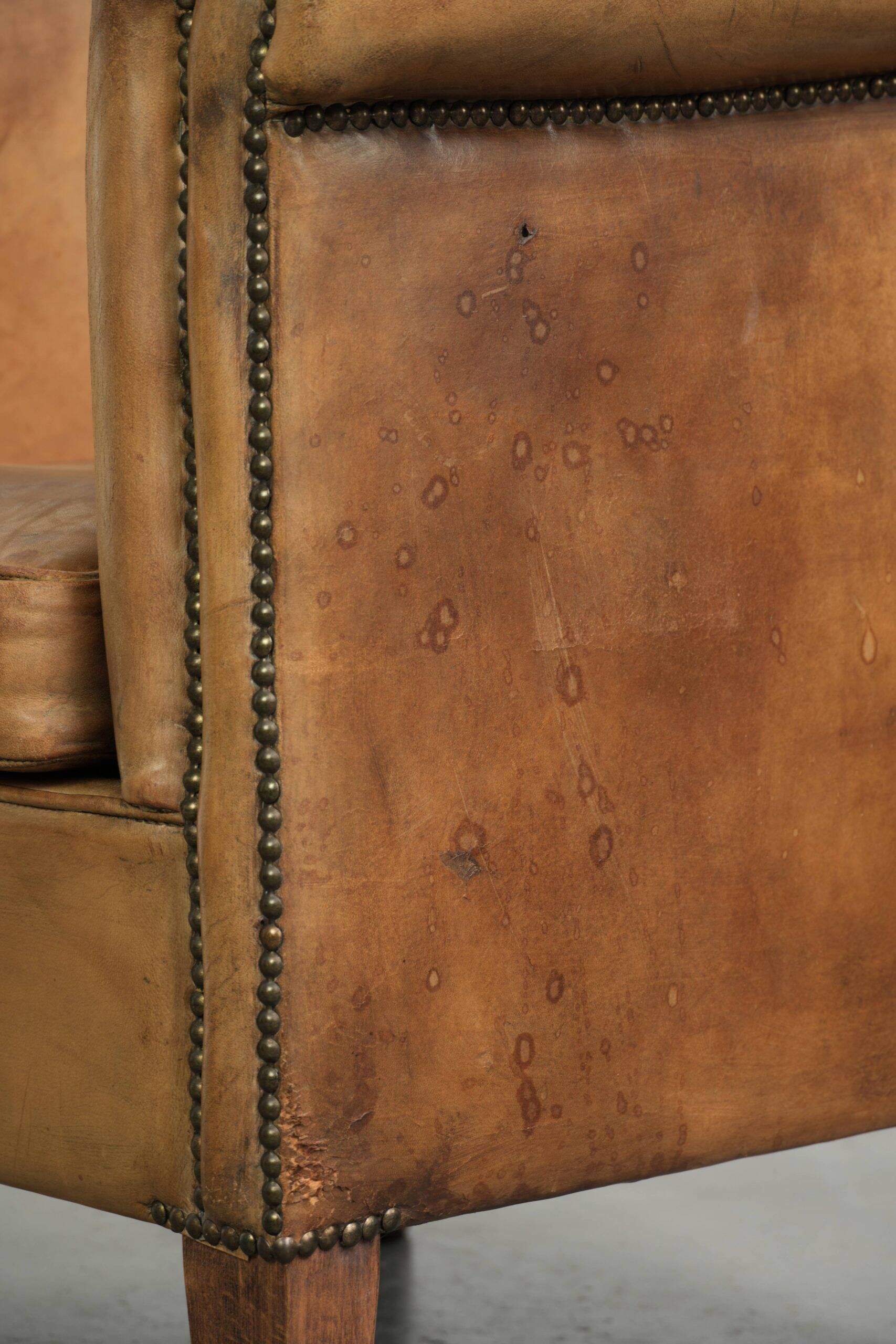 Fauteuil club en peau de mouton confortable de couleur cognac.