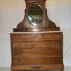 Antique carved wooden dressing table with marble and tilting oval mirror.