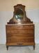 Antique carved wooden dressing table with marble and tilting oval mirror.