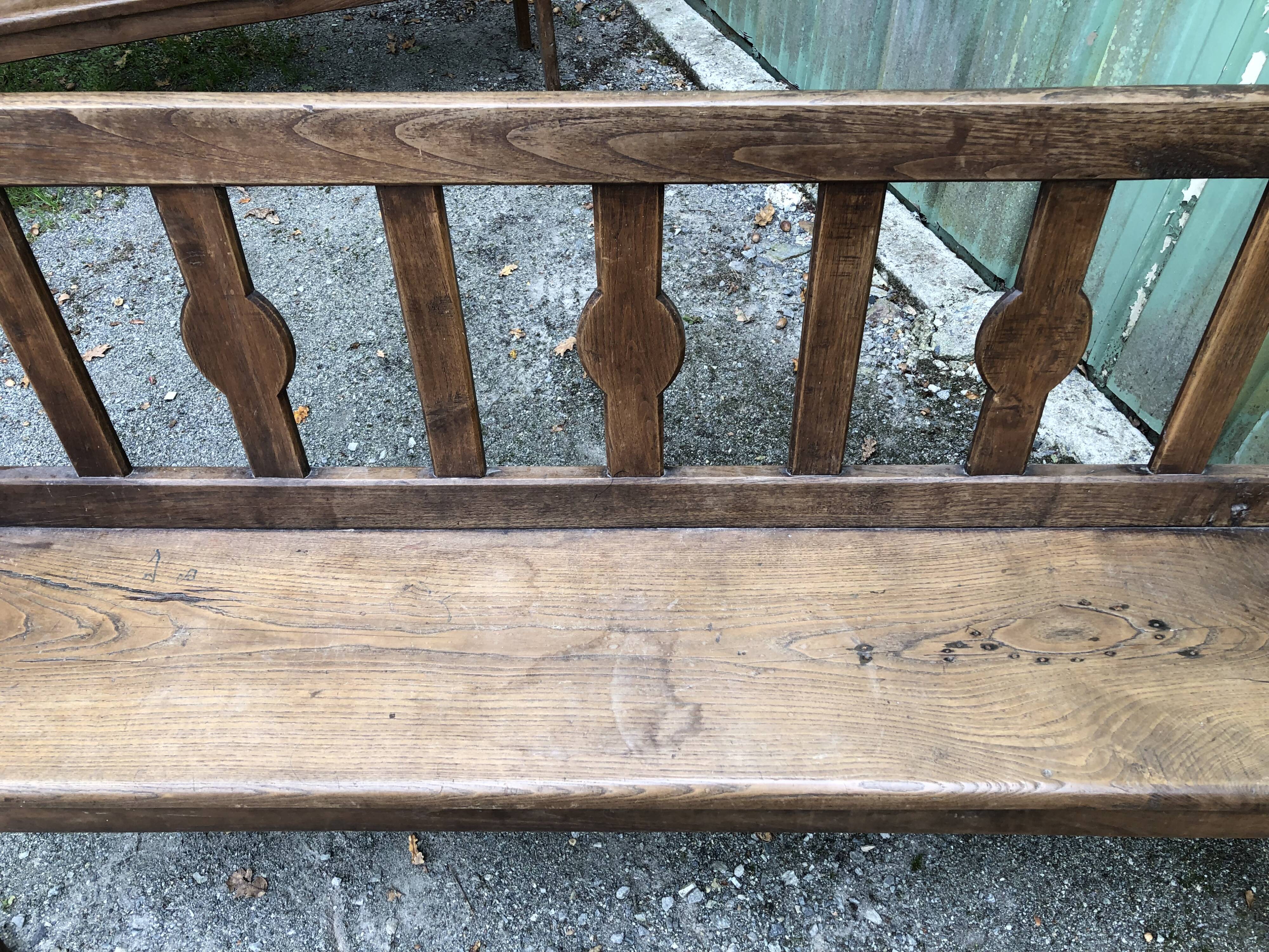 Duo of old solid oak benches with backs and armrests.