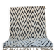 Tapis berbère en laine écrue à motifs noirs