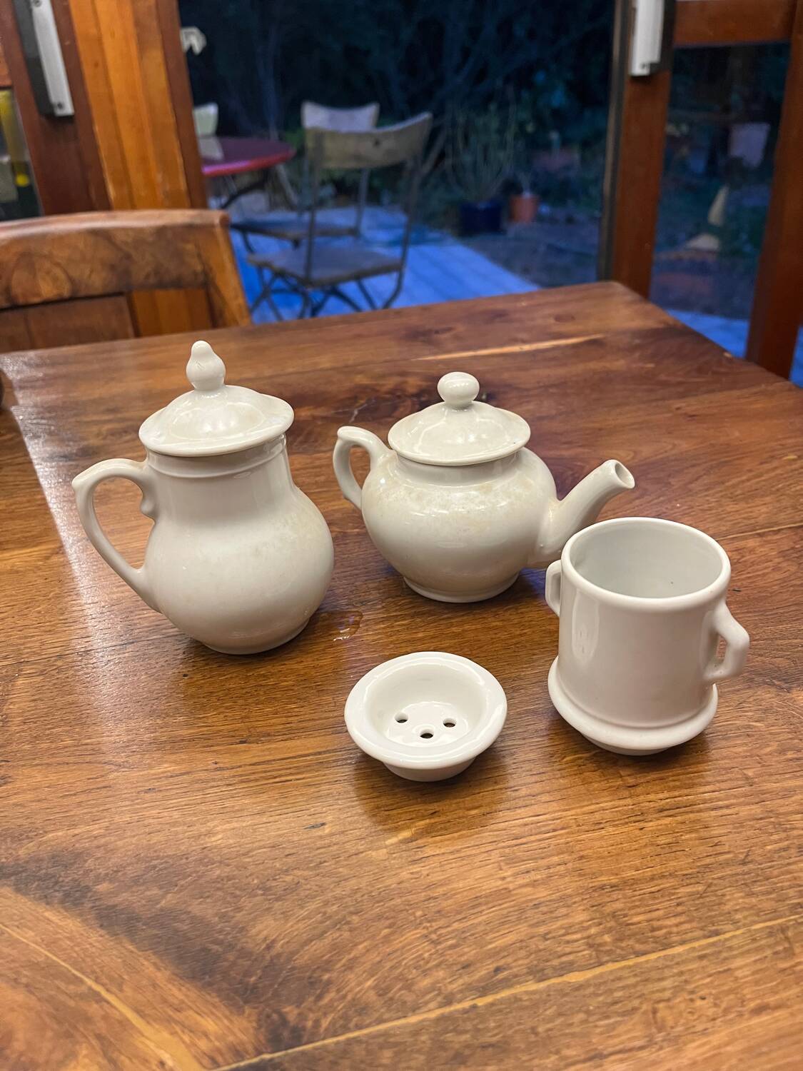 Antique white earthenware teapot, individual service with filter.
