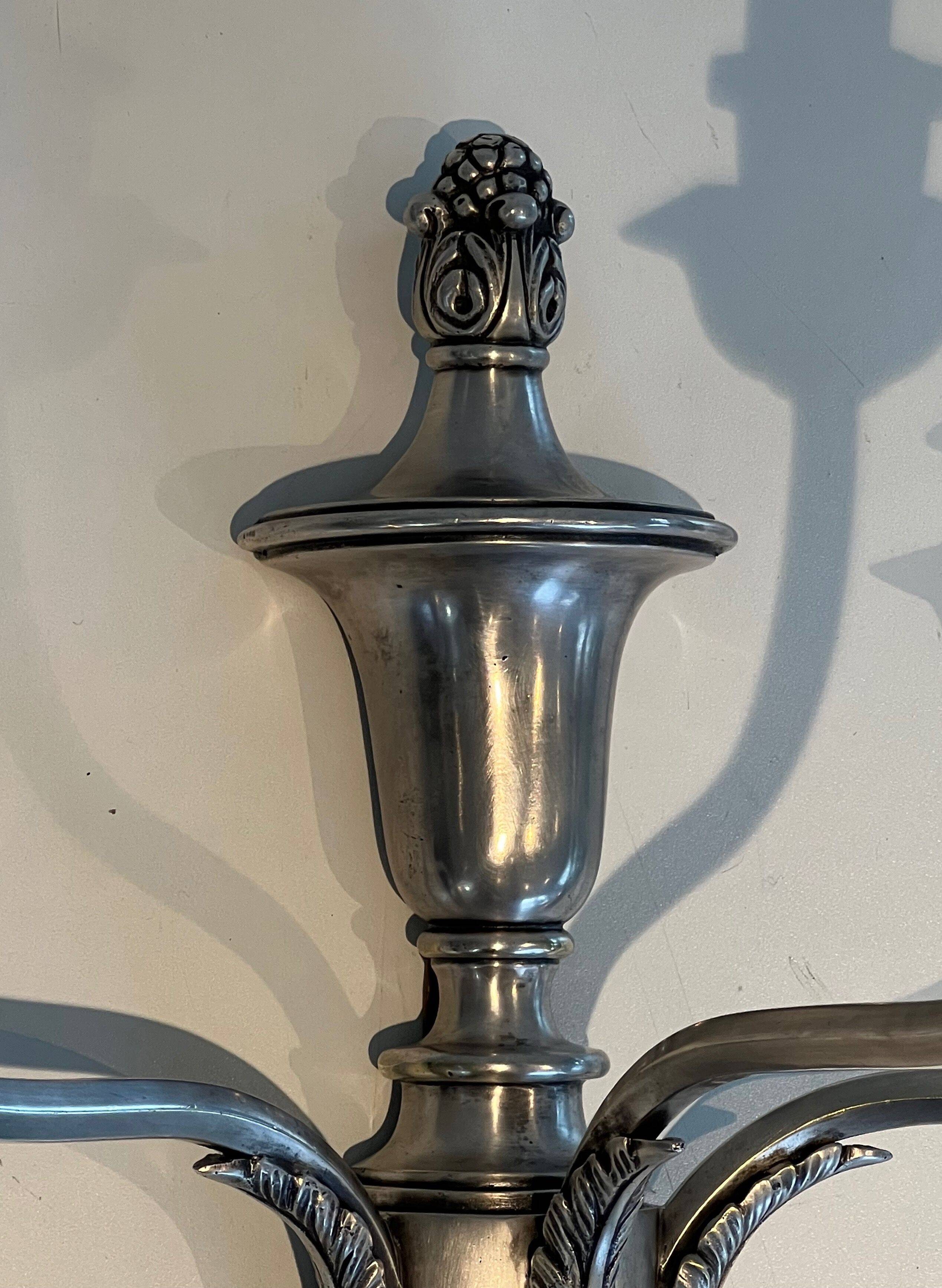 A pair of important Louis XVI style silver-plated wall sconces with three light arms.
