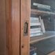 Antique wooden sideboard with three sliding glass doors.