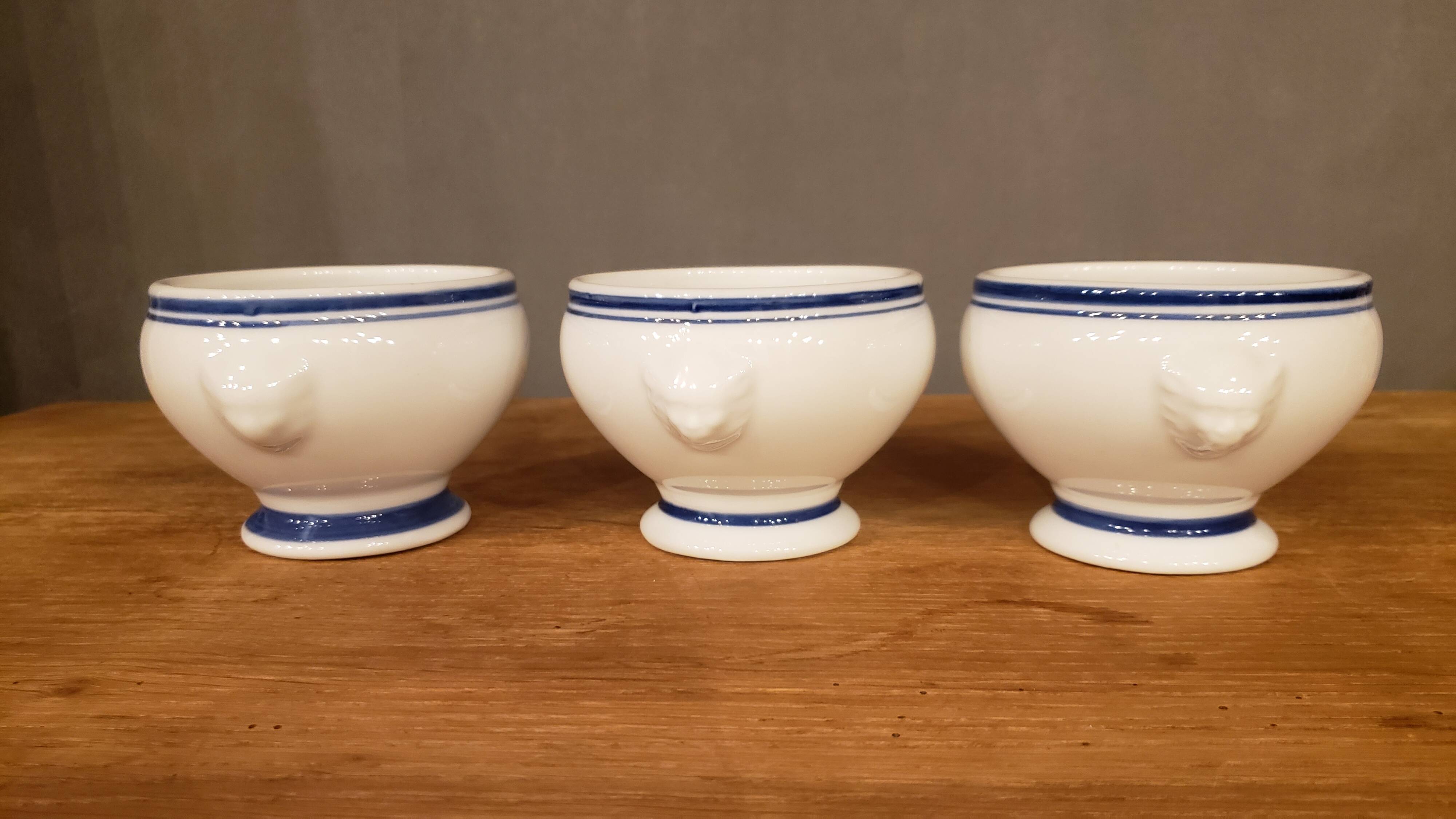 8 white lion head soup bowls with blue edging