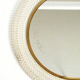 Mid Century Modern round wall mirror with a white expanded metal frame