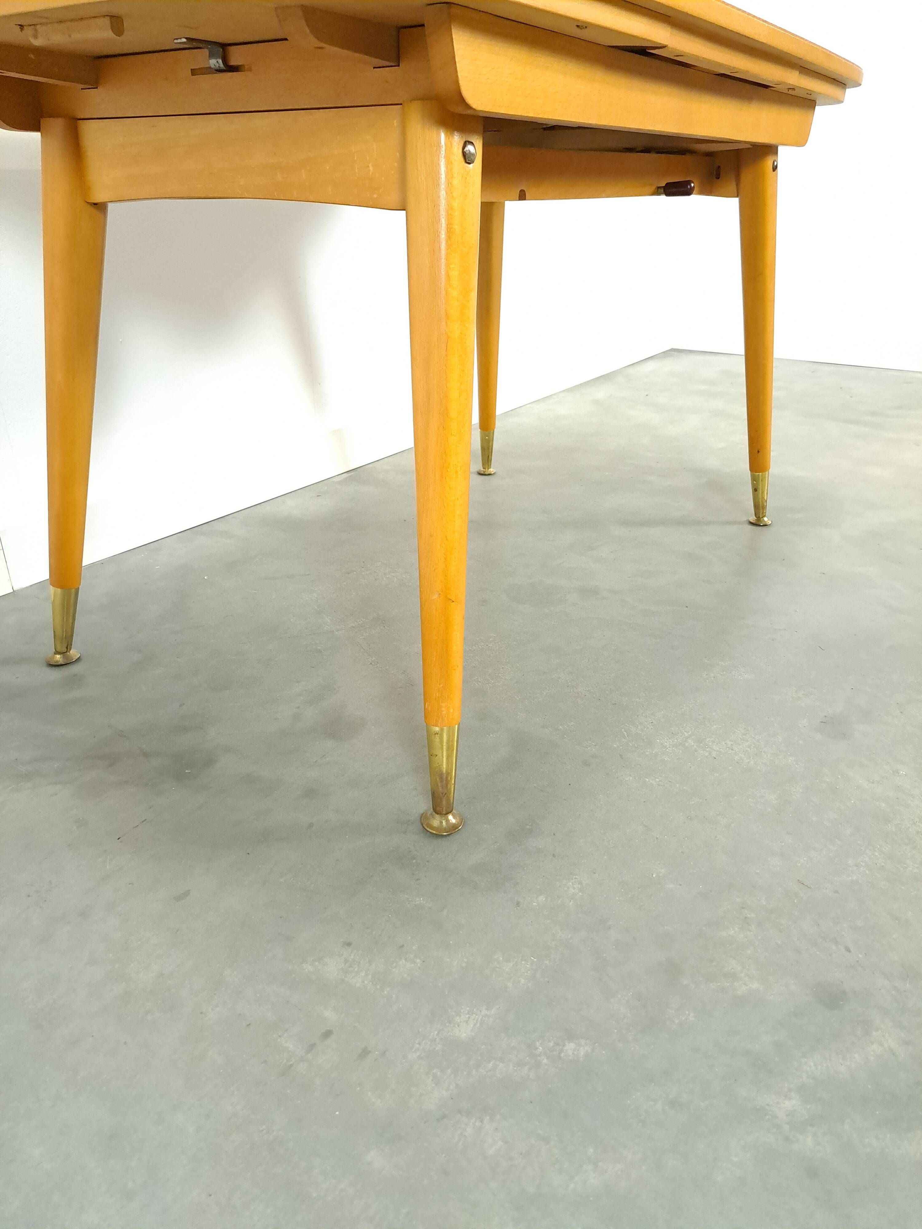 Vintage veneer table with pretty angular legs and brass at the base of the legs.