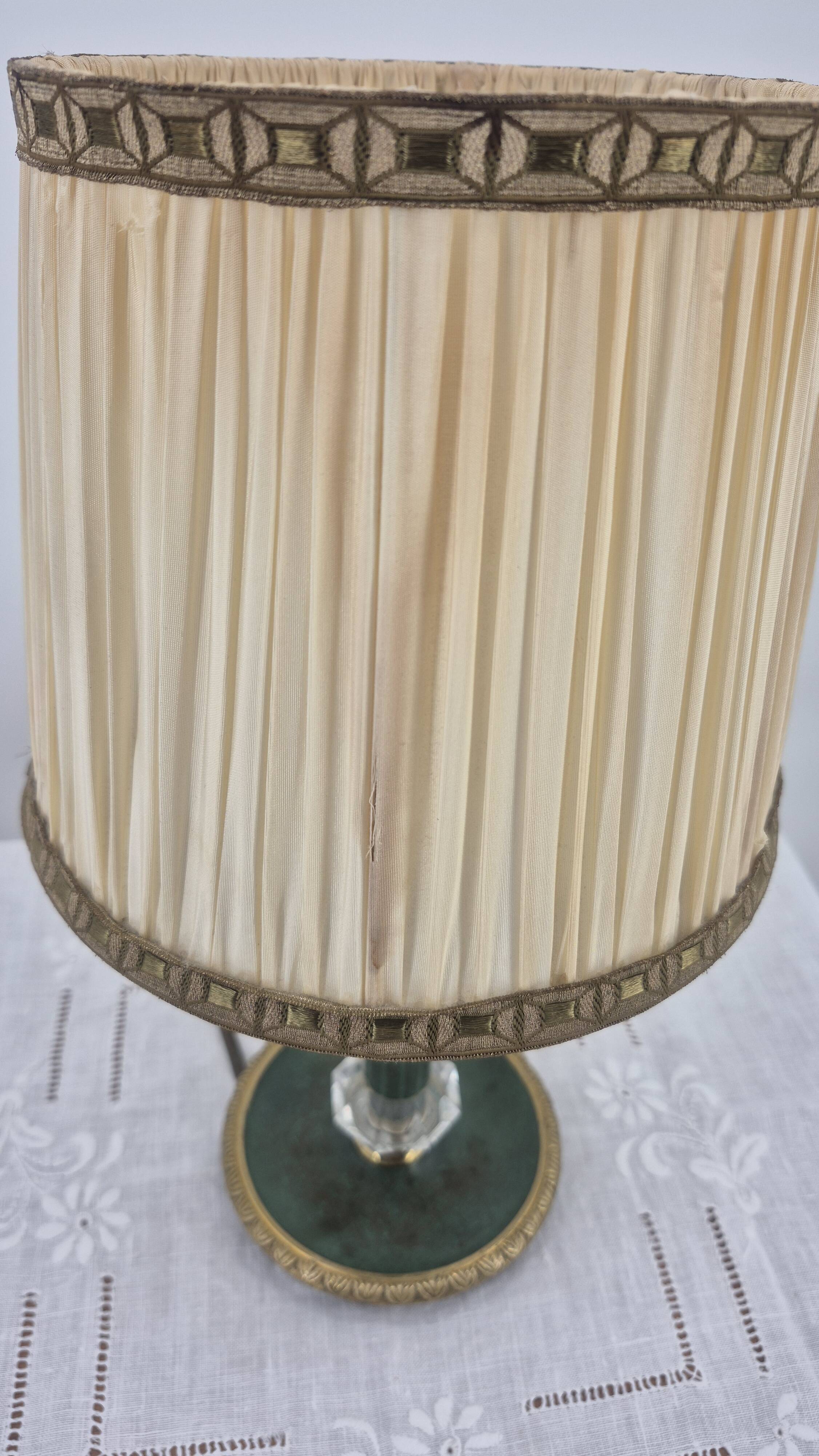 Brass table lamp with green patina and empire-style fabric shade.
