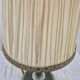 Brass table lamp with green patina and empire-style fabric shade.