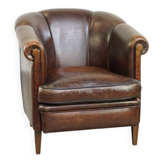 Dark sheep leather club chair with uniquely shaped armrests