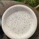 4 black speckled dessert plates on a vintage white background
