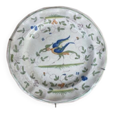 Hollow plate in Moustiers faience decorated with a bird, 19th century.