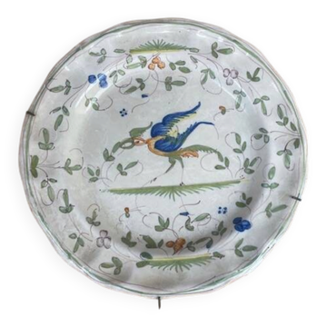 Hollow plate in Moustiers faience decorated with a bird, 19th century.