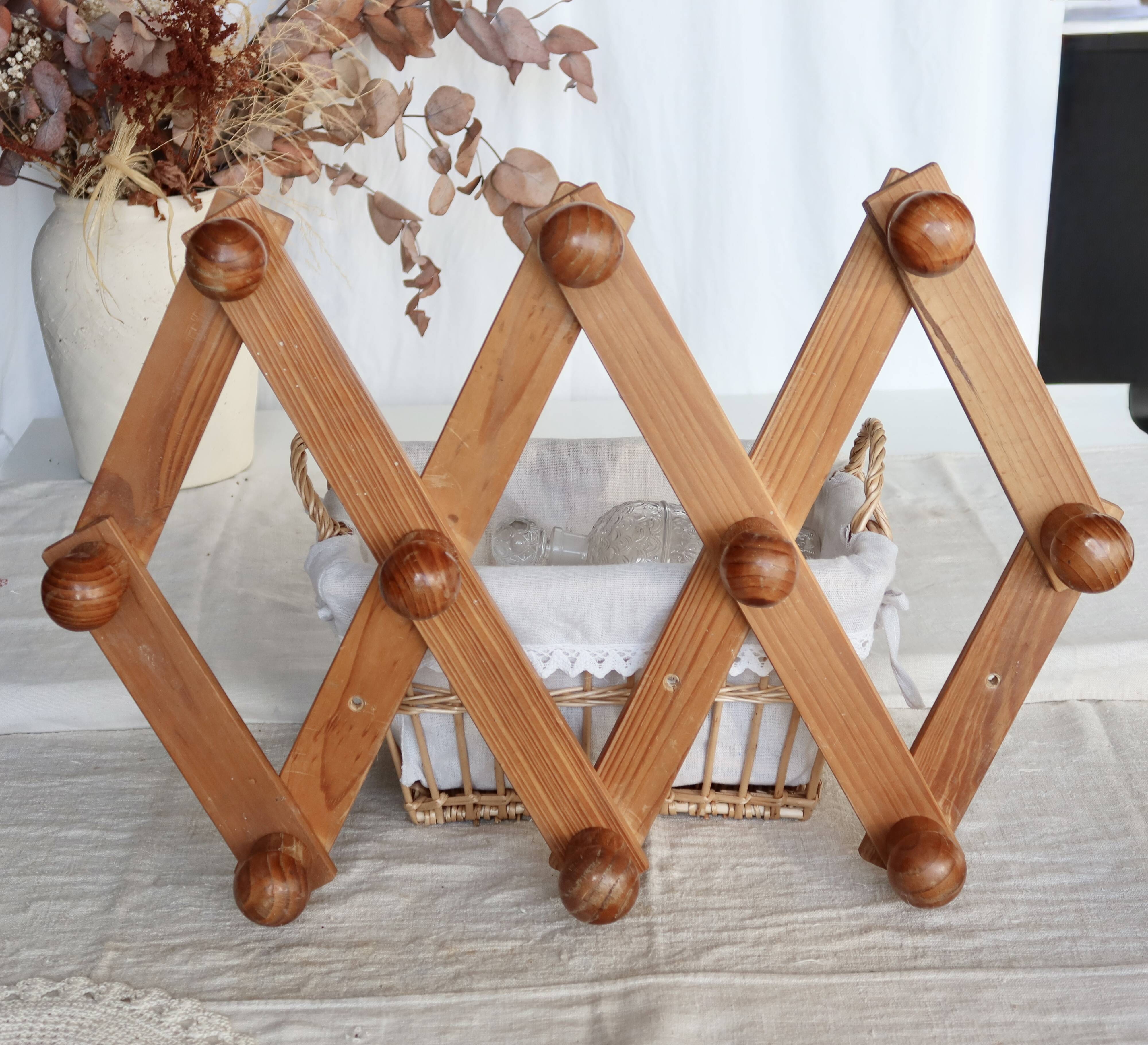 Antique wall-mounted coat rack accordion in dark pine, 10 wooden hooks.