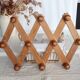 Antique wall-mounted coat rack accordion in dark pine, 10 wooden hooks.