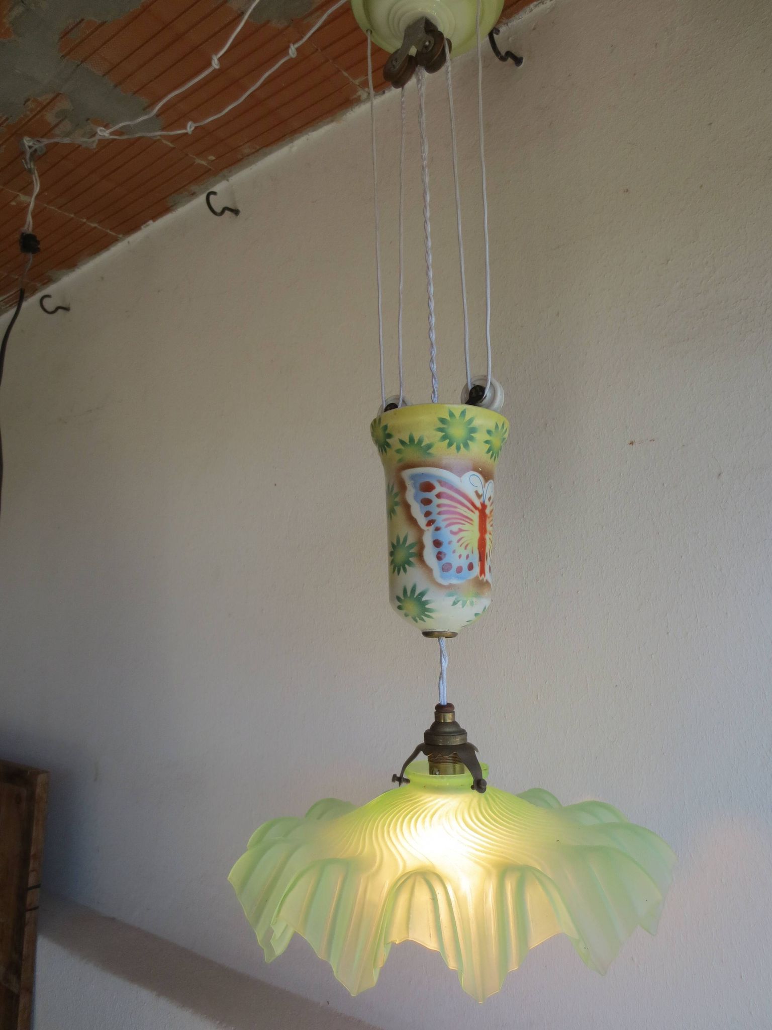 "Very old light fixture" with a "rise and fall" counterweight adorned with butterflies.