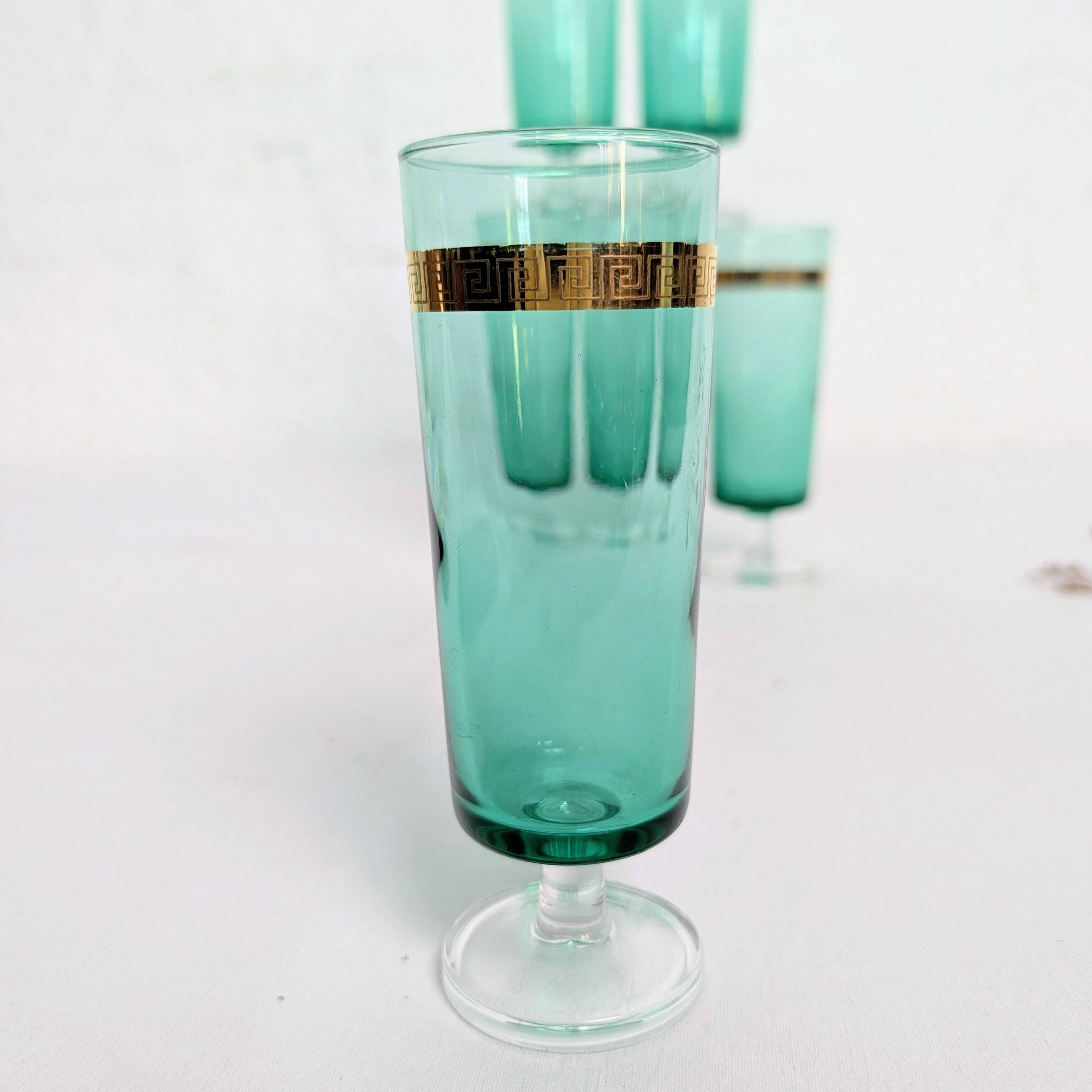 Set of 6 green champagne flutes with a golden rim.
