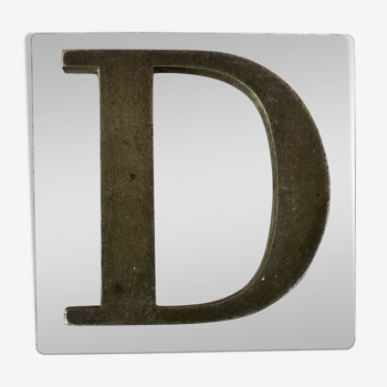 Metal letter D on glass plate