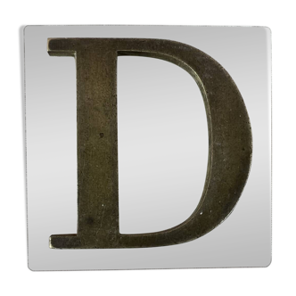 Metal letter D on glass plate