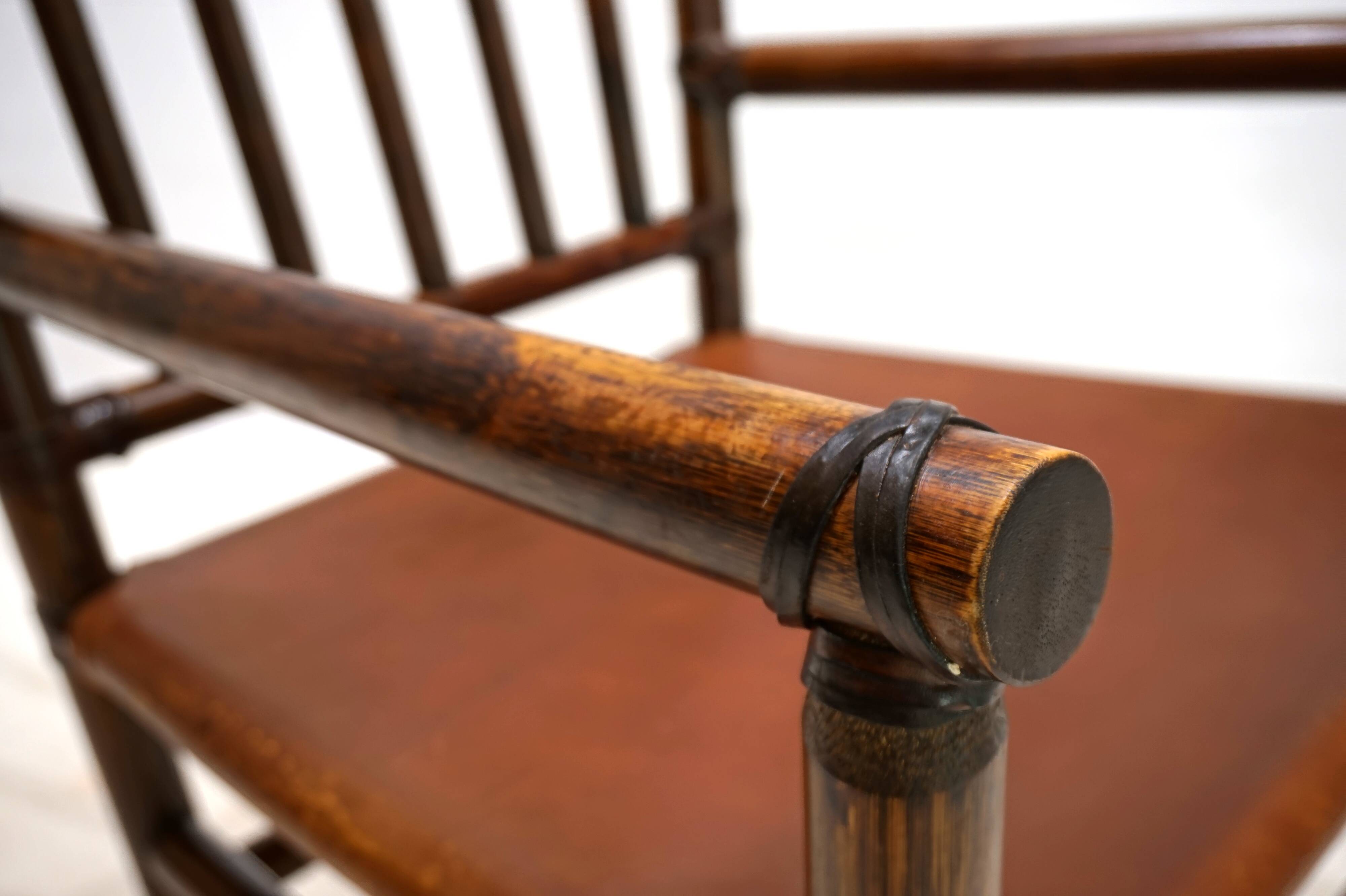 Fauteuil Manou en rotin et assise en cuir, 1960