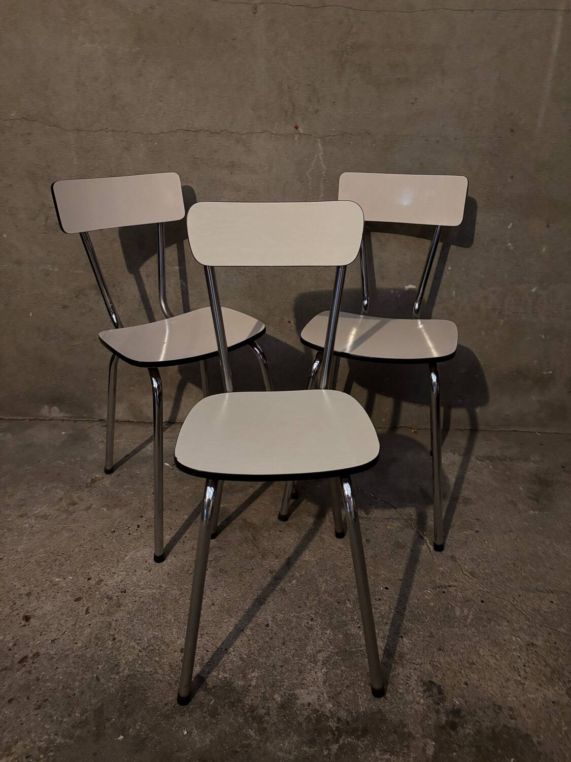 3 white Formica chairs