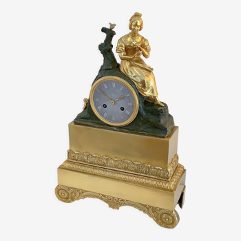 Figurative fireplace pendulum in gilded bronze and double patina early xixth century