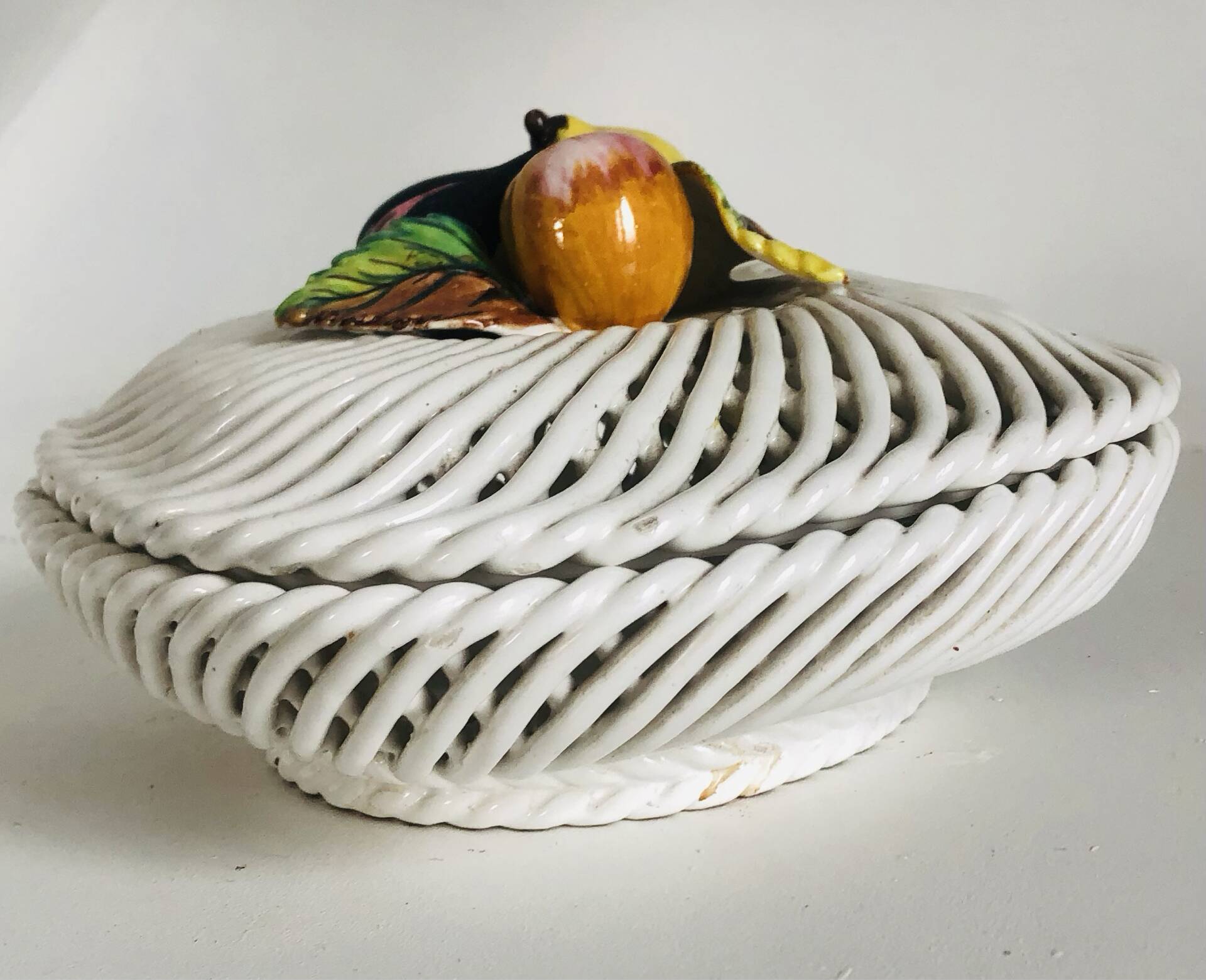 Covered basket in white woven ceramic and fruit slip.