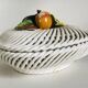 Covered basket in white woven ceramic and fruit slip.