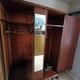 Vintage 1960s wooden wardrobe with a central mirror and tapered legs.