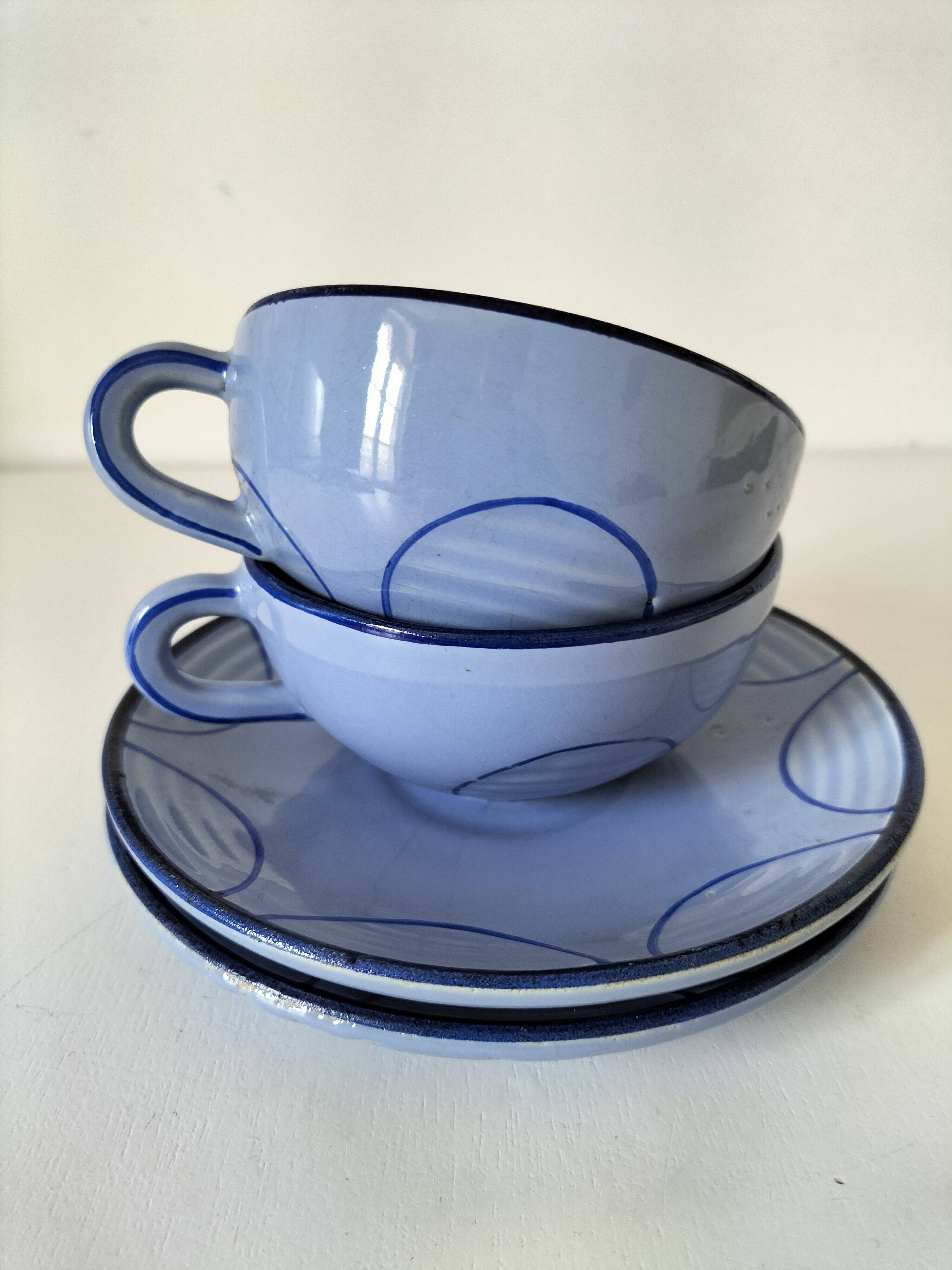 A pair of glazed ceramic cups and saucers from the 60s-70s.