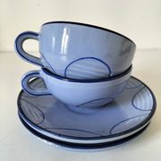 A pair of glazed ceramic cups and saucers from the 60s-70s.