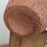 Terracotta vase with gradient of black faded to half on an earth-colored background
