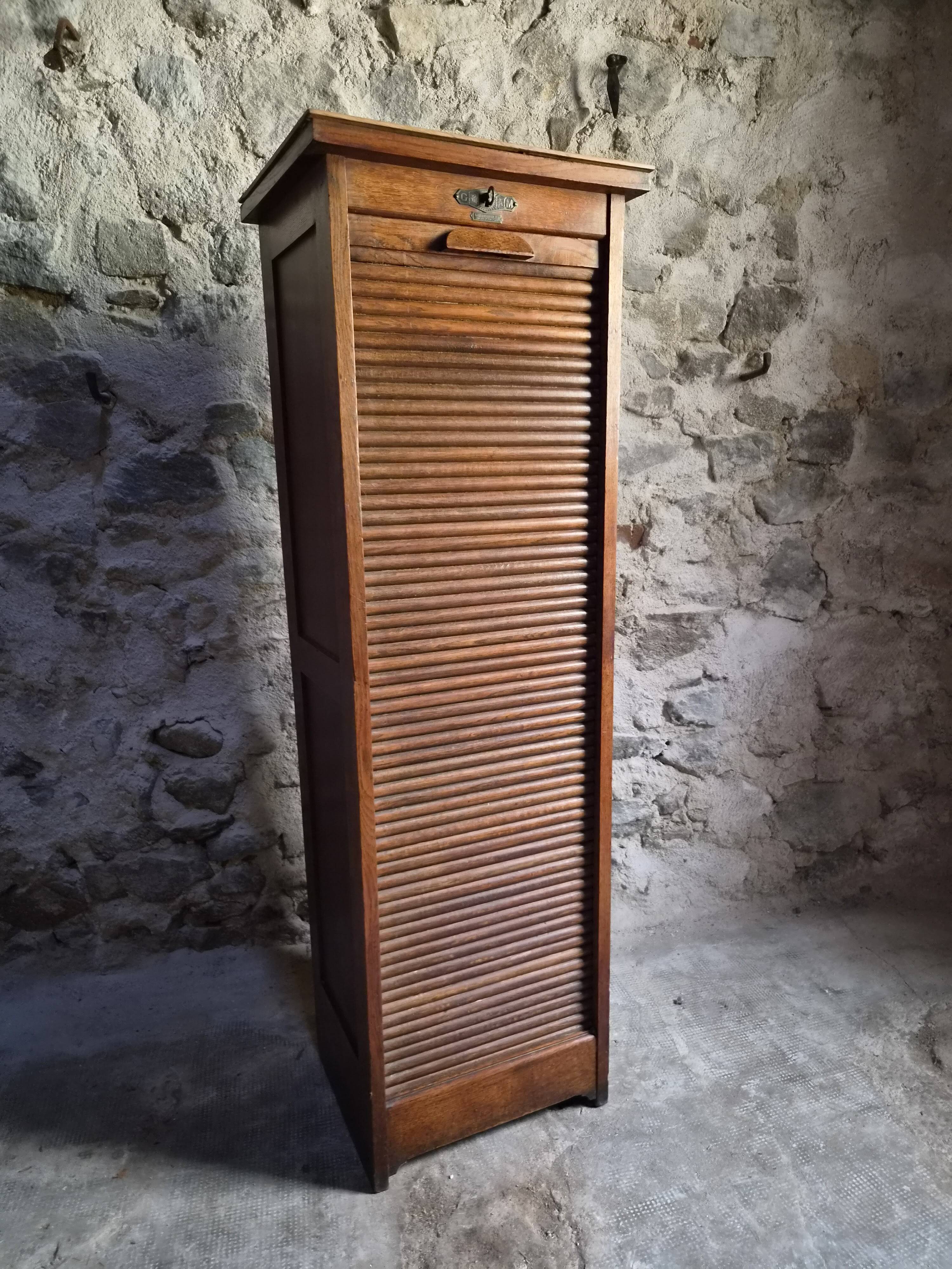 French antique wardrobe with curtain in oak, circa 1920–1930.
