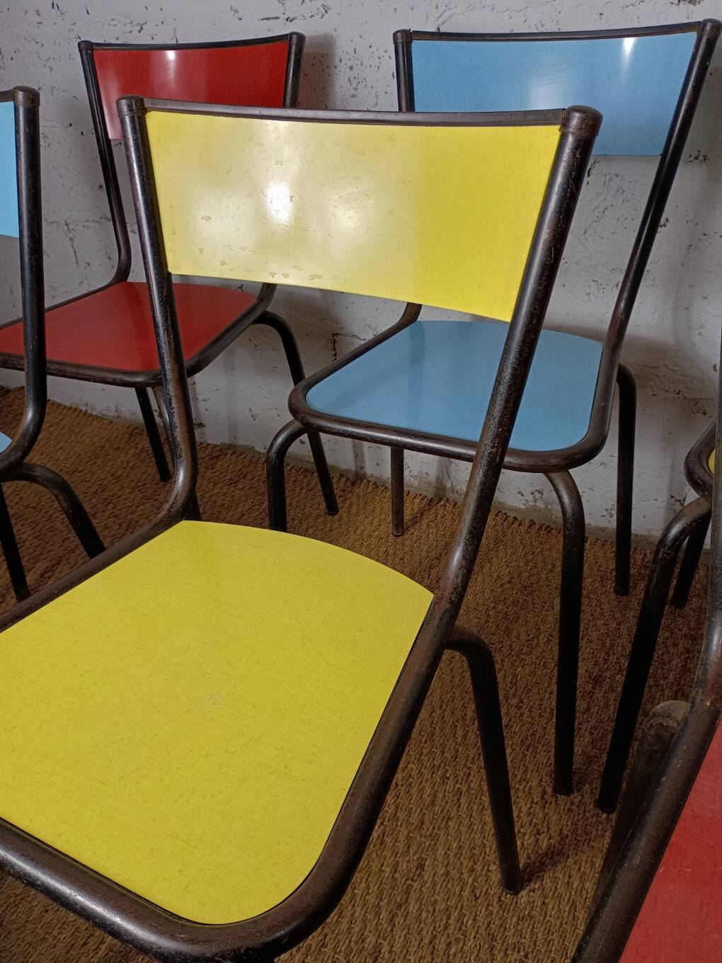 8 canteen chairs, yellow, blue, and red Formica with metal tubing from the 1950s-60s.