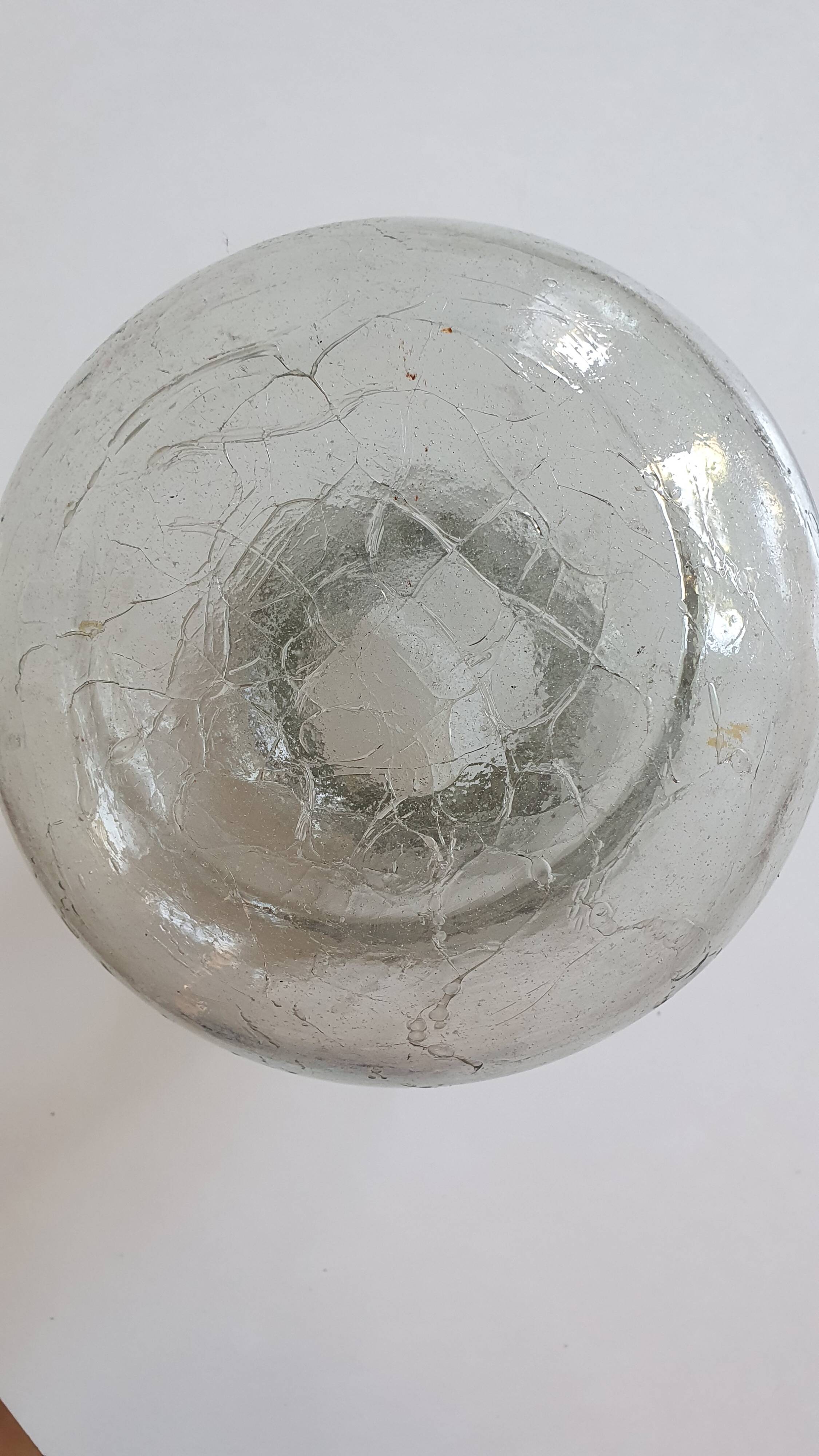 Cracked glass vase encircled with wrought iron.