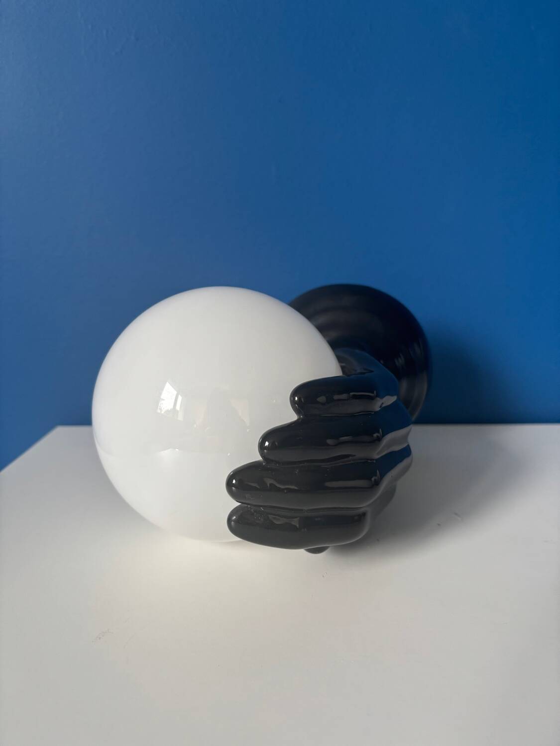 Vintage wall sconce with black hand and white opaline glass globe, 1970s L