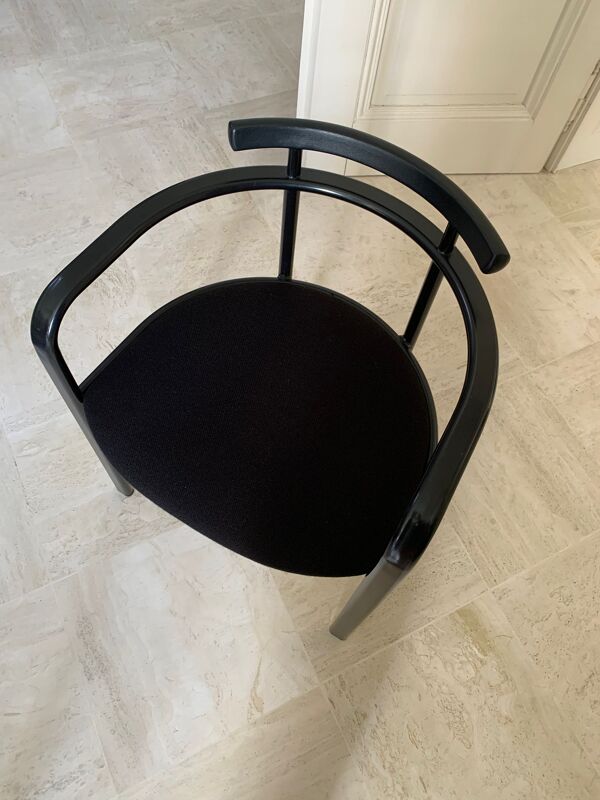 Table de salle à manger noire, en bois, rectangle avec chaises rembourrées.