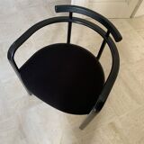Table de salle à manger noire, en bois, rectangle avec chaises rembourrées.
