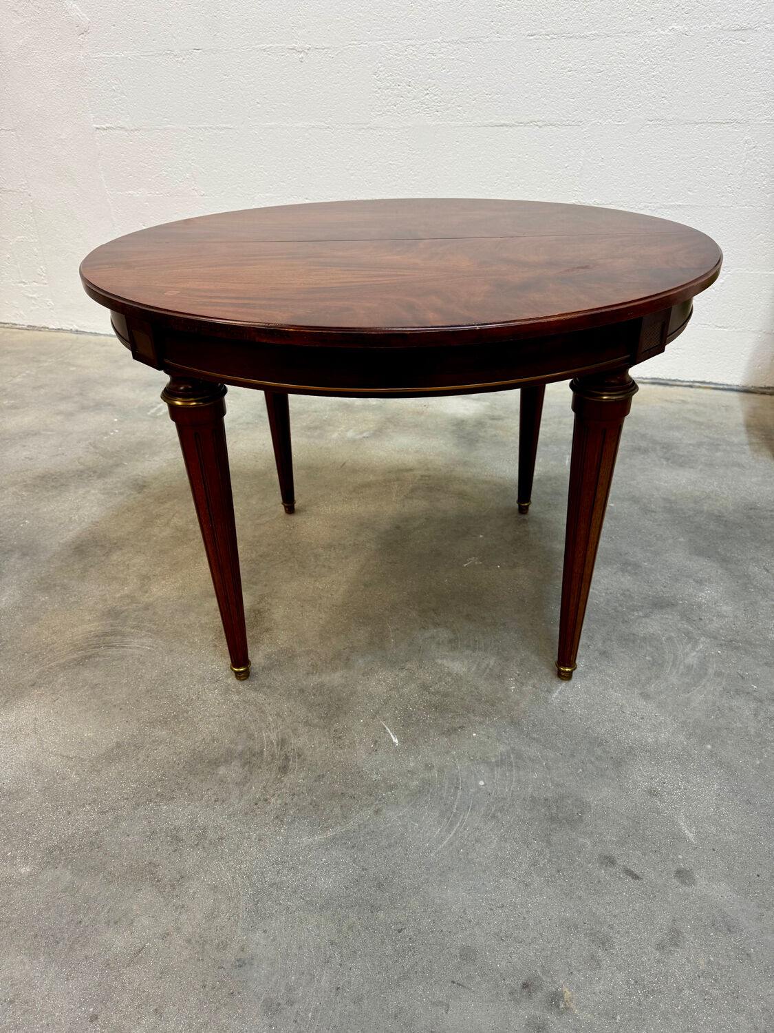 Extendable mahogany round table in Louis XVI style